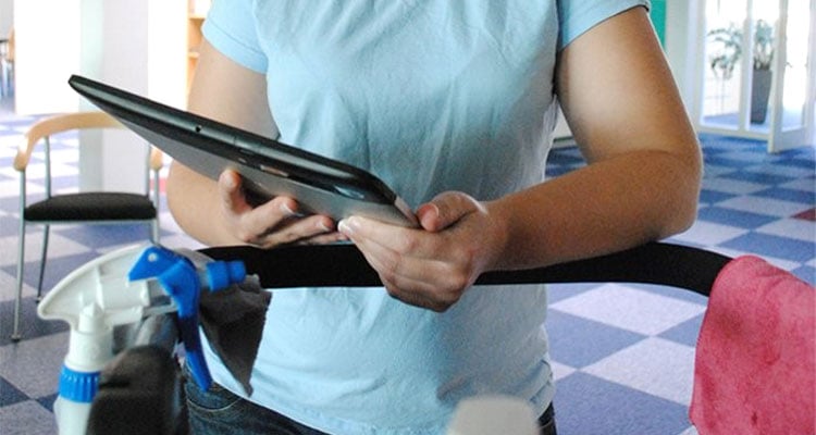 Rengøringsassistent holder tablet i hånden